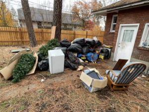 A large pile of household junk, including trash bags, an old refrigerator, and furniture, ready for removal by Timber Moose Dynamics LLC in Spokane, WA.