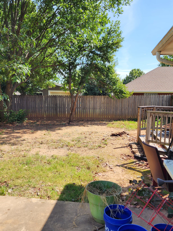 A residential backyard after land clearing and tree removal services by Bar M Tree Care in Fayetteville, AR.