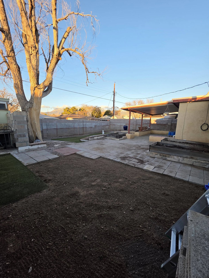 A backyard undergoing landscaping work with dirt and pavers, by Luis handyman service in Albuquerque, NM