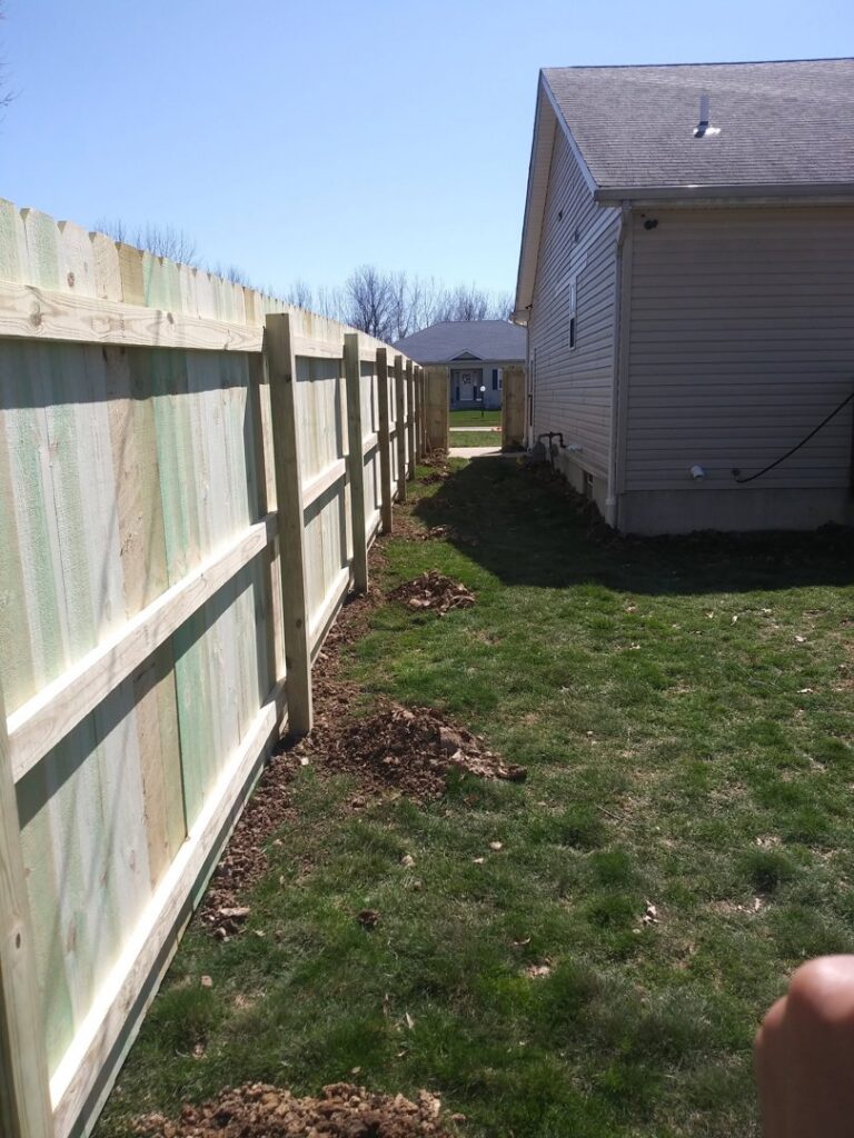 A newly installed wooden privacy fence in a residential backyard by Ofandiski Fence Co. Inc in Lorain, OH.