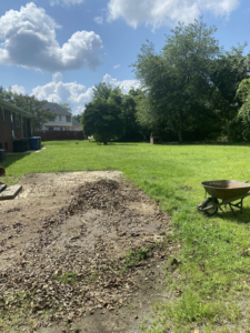 A backyard patio covered in leaves and debris, ready for cleanout and removal by Woodlawn Hauling & Junk Removal in Alexandria, VA.