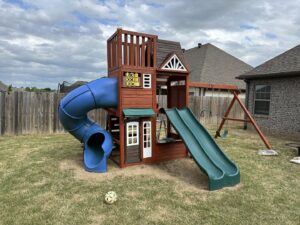 A large wooden playset with slides and swings assembled by I Know A Guy Handyman Service in Cottage Grove, MN.
