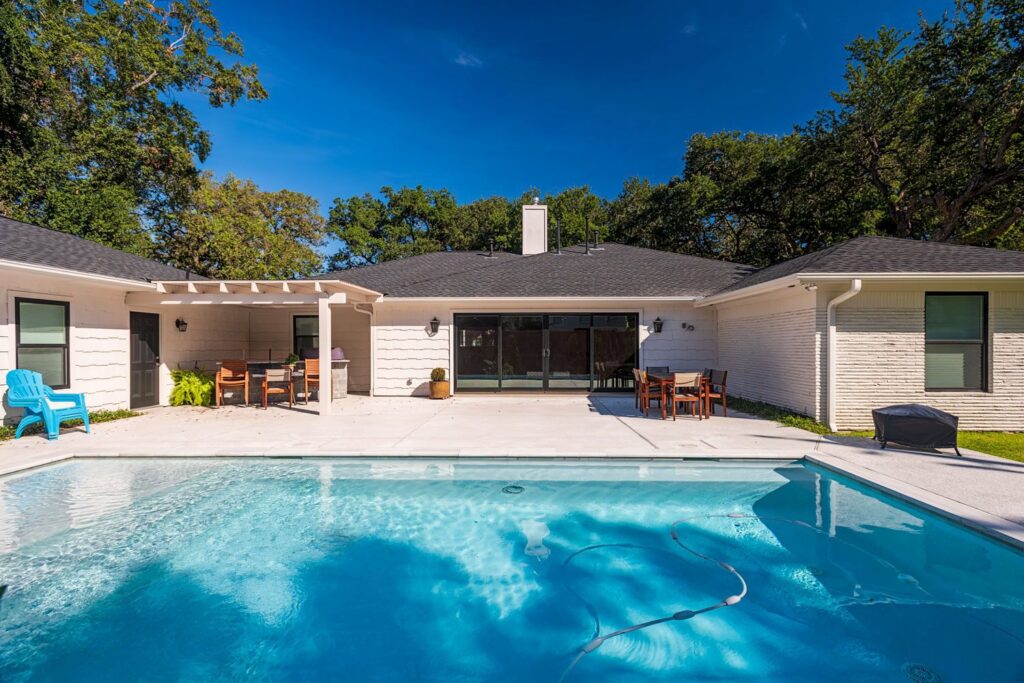 A backyard with a newly installed swimming pool and patio by All Star Construction, Inc. in Houston, TX.