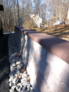 A sturdy stone retaining wall in a backyard, expertly built by Landscape By Today in Bowie, MD.