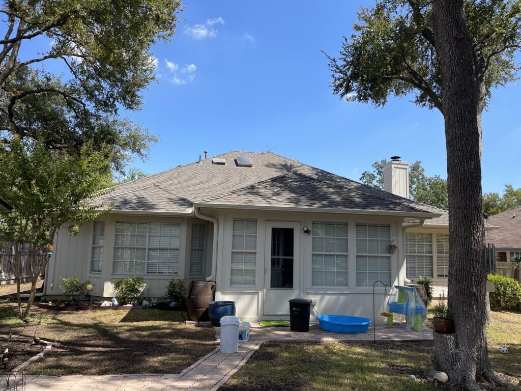 Backyard view of a residential house with a newly installed roof by Austin Roofing and Construction in Austin, TX.