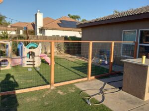 Backyard wire fence installation with wooden posts by Cal Heights Construction And Handyman Services in Bakersfield, CA