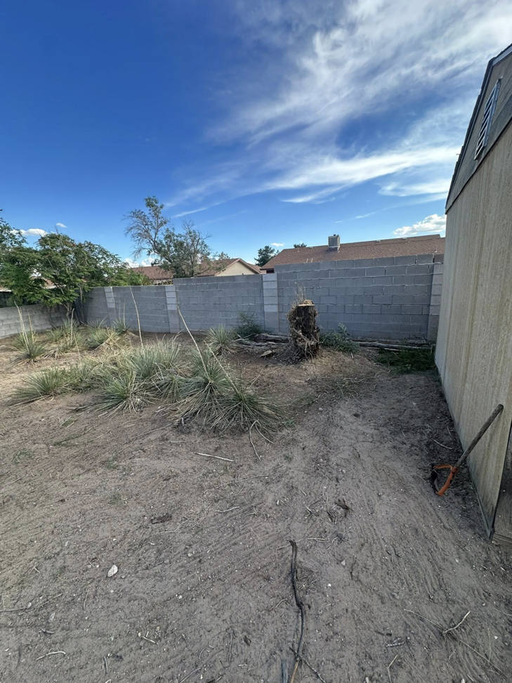 A backyard showing a tree stump removed and land cleared by Appleton Residential Services in Rio Rancho, NM.