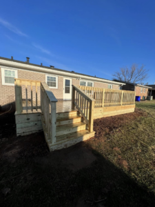A spacious backyard wooden deck with steps leading to the yard, installed by Matt Hingle Construction in Bowling Green, KY.