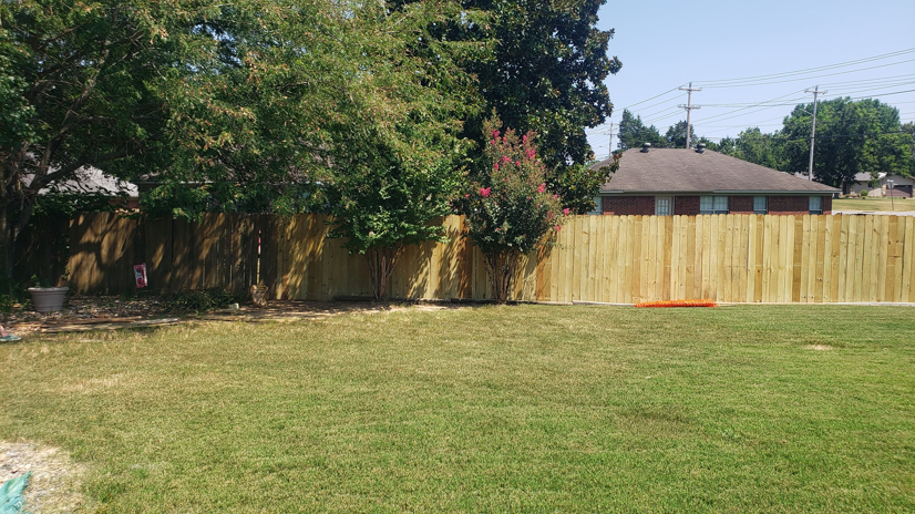 A backyard with a newly installed or repaired wooden fence, demonstrating quality work by Wilcox Handyman Services in Conway, AR.