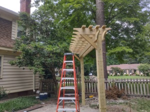 A wooden pergola being built in a backyard by Signature Deck & Pergola in Virginia Beach, VA