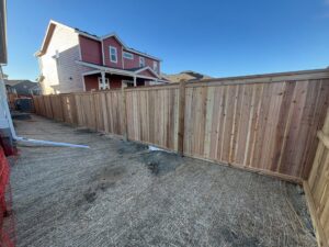 A newly installed wooden privacy fence in a backyard by Blue Collar Service Pros in Aurora, CO.