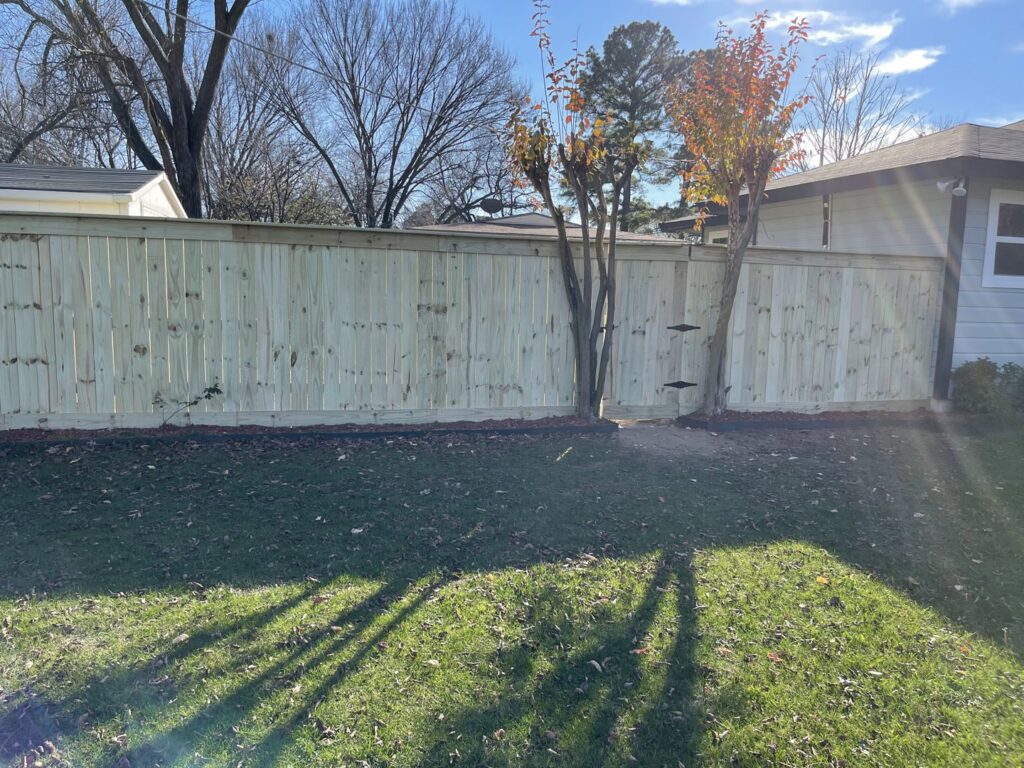 A newly installed wooden privacy fence in a backyard, completed by Brewer Builds in Fort Worth, TX.
