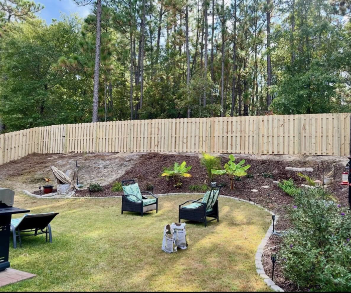 A newly installed wooden privacy fence in a backyard by Legacy Fence, LLC in Aiken, SC, enhancing property aesthetics.