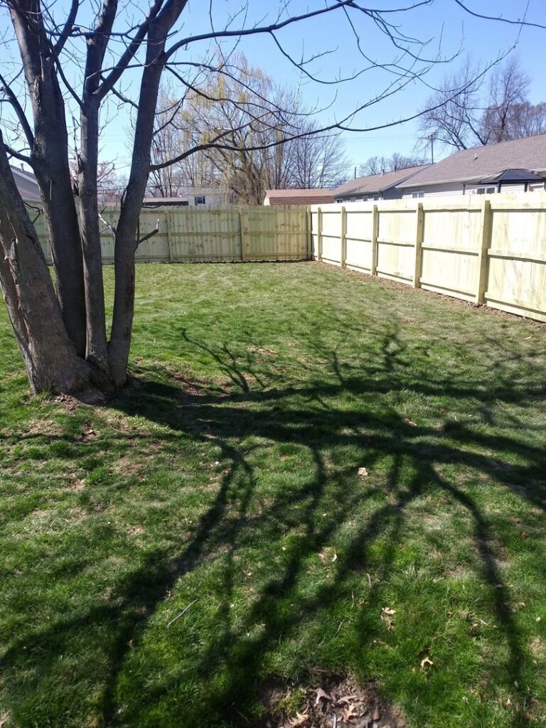 A new wooden privacy fence installed in a residential backyard by Ofandiski Fence Co. Inc in Lorain, OH.