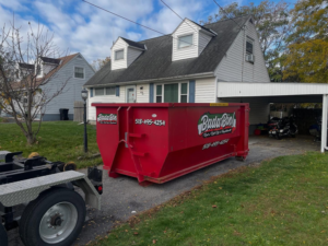 A Bada Bin junk removal dumpster delivered to a residential driveway in Schenectady, NY, ready for a cleanup job.
