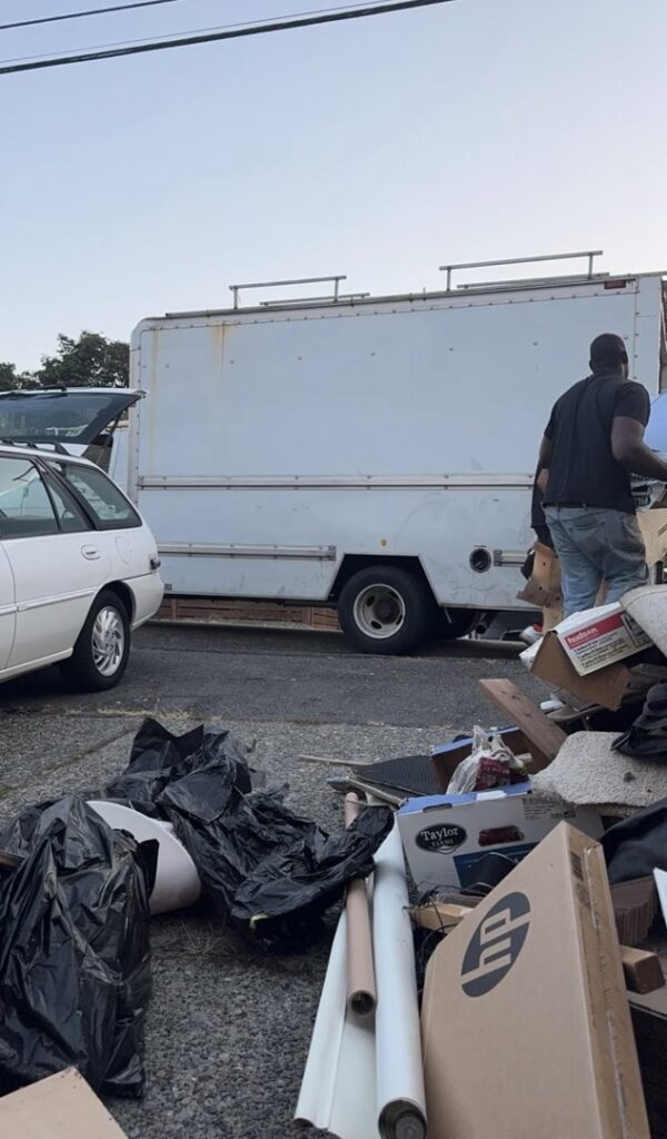 A residential balcony filled with old wooden furniture pieces, including dressers and chairs, awaiting removal by JUNK IN THEE TRUNK in Kent, WA.