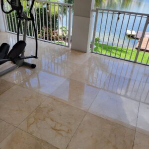 A restored and polished marble tiled balcony overlooking a serene lake, completed by Cornerstone Services Management in Miami, FL.
