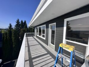 Balcony railing painting in progress with a ladder and paint can by J&R Buezo Painting Services LLC in Everett, WA