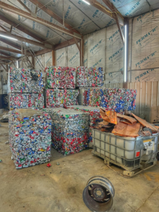 Bales of crushed aluminum cans and a bin of scrap metal inside the Tenn-Scrap facility in Jackson, TN.
