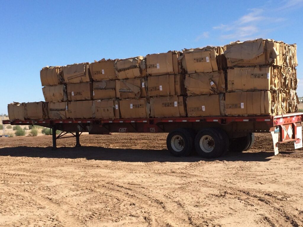 Baled cardboard boxes stacked on a flatbed trailer for recycling or waste transport by A Track-Out Solution in Las Vegas, NV.