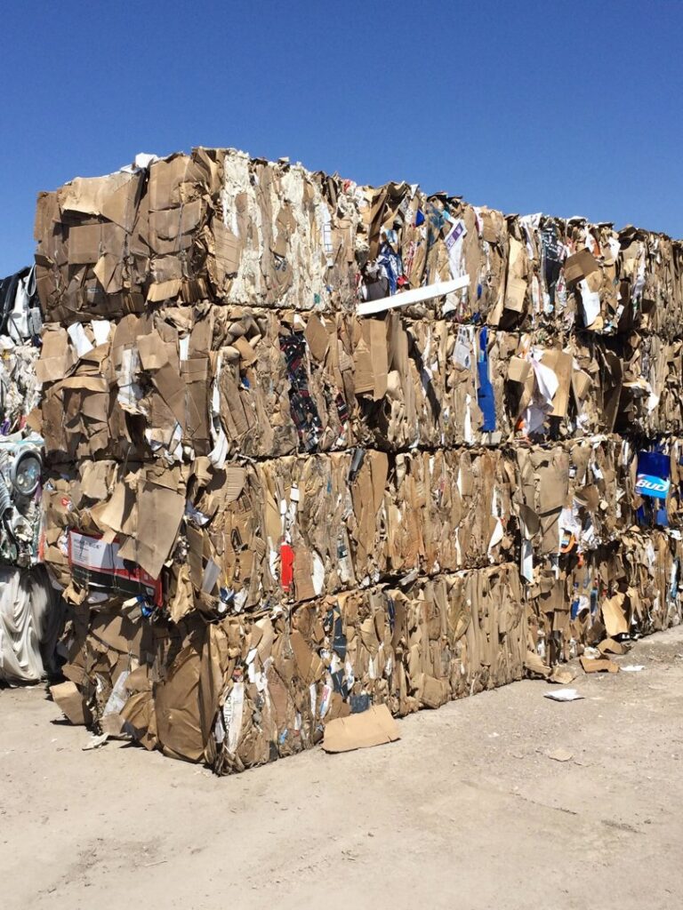 Large stacks of baled cardboard and mixed waste for recycling or disposal by A Track-Out Solution in Las Vegas, NV.