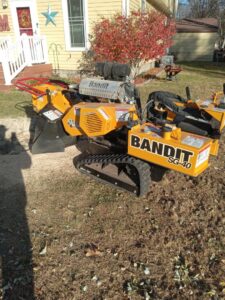 A yellow Bandit SG-40 stump grinder on a residential lawn, used by Grand Island Tree Service in Grand Island, NE.