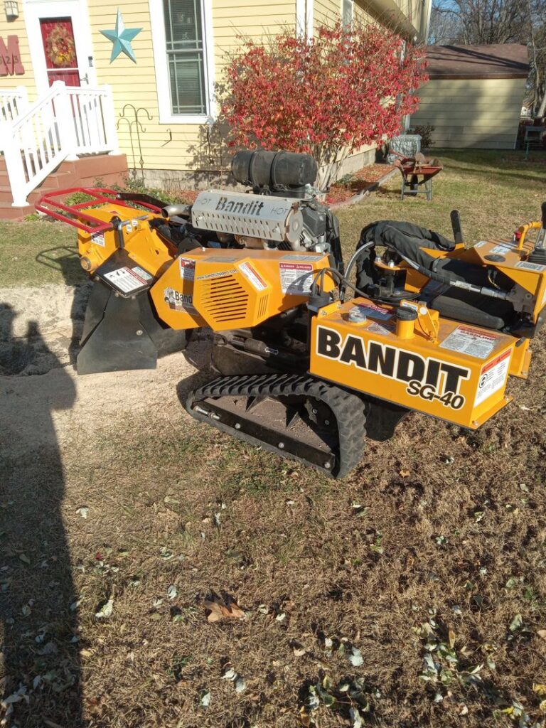 A yellow Bandit SG-40 stump grinder on a residential lawn, used by Grand Island Tree Service in Grand Island, NE.