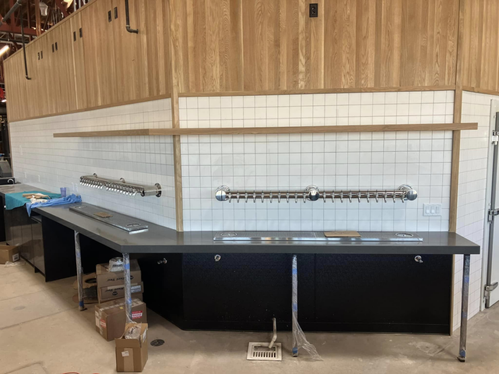 A new bar beverage system being installed with multiple taps and tiled wall by Black Tide Beverage in Lakewood, CO.