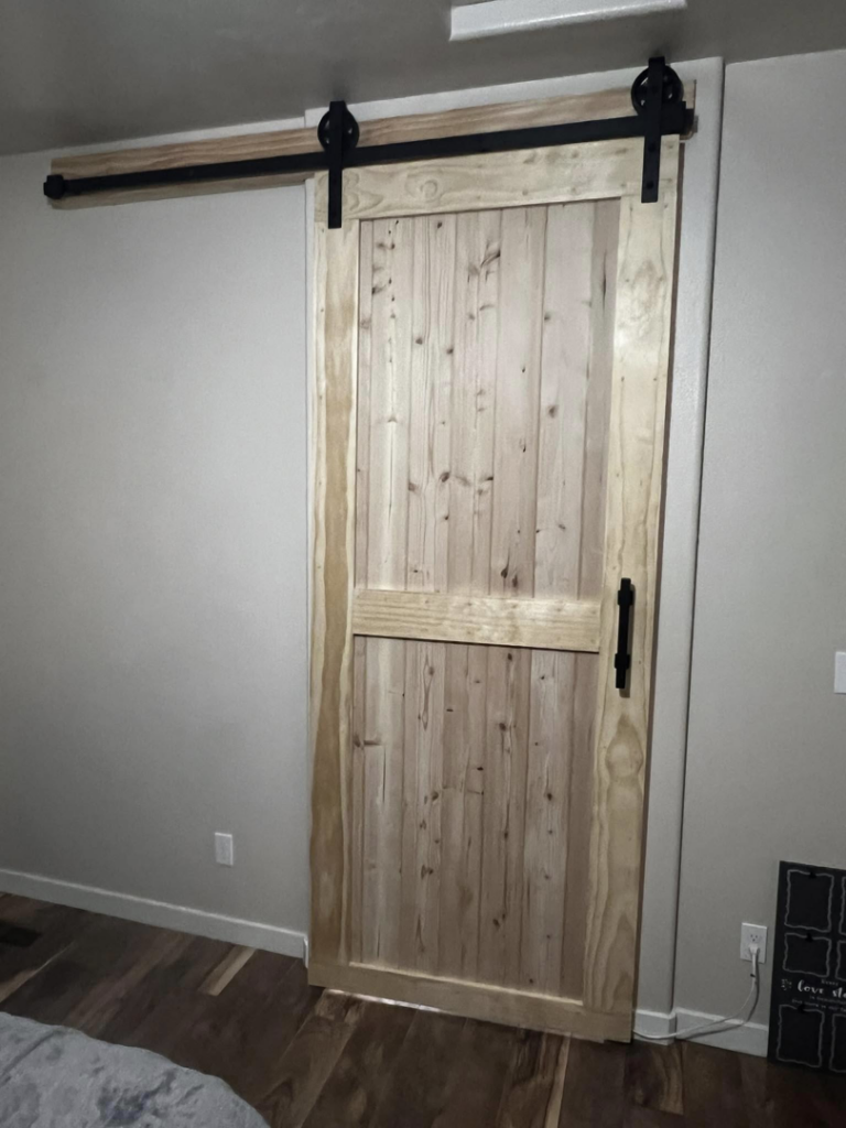 Detailed view of a barn door with black sliding hardware installed by E&D Lozano Handyman in Caldwell, ID.
