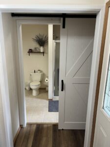 A modern barn door installed at a bathroom entry by 1775 Handyman Services in Kalispell, MT.