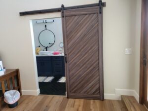 A newly installed barn door leading into a bathroom, completed by McCarran Handyman Services in Boulder City, NV.