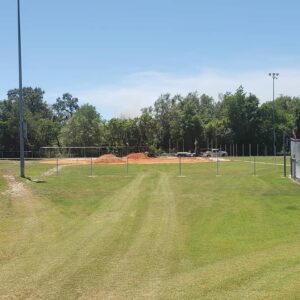 Baseball field showing new fence post installation and dirt piles by Keeler Fence in New Port Richey, FL.