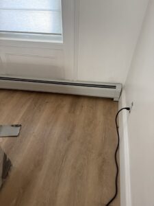 New baseboard heating unit installed along a wall with light wood flooring by Clear Flow Plumbing, Heating, and Hvac Contractors LLC in Jersey City, NJ