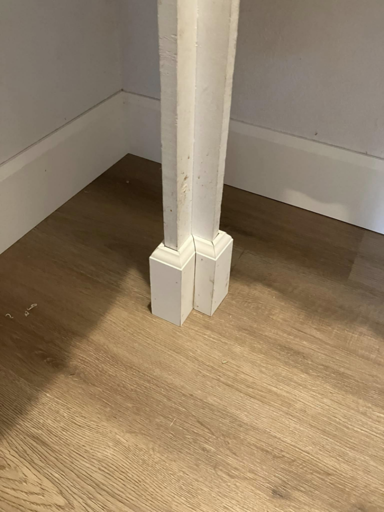 Close-up of newly installed baseboard trim and a column base, showcasing handyman finish carpentry by JMY Construction in Meridian, ID.