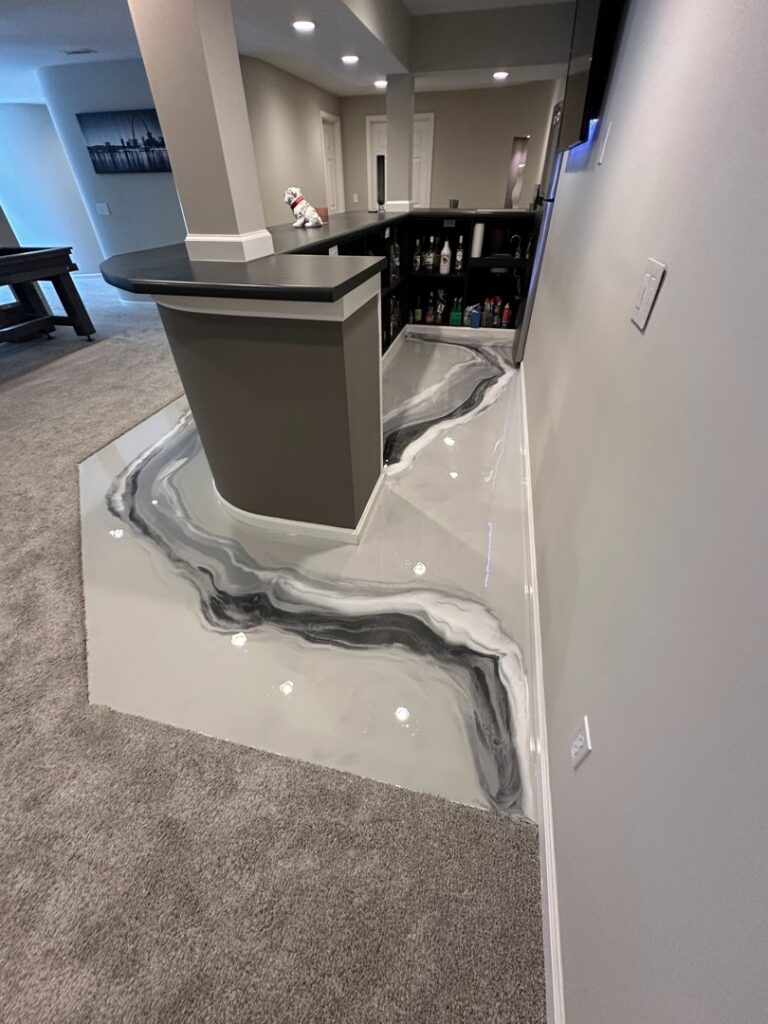 A stylish basement bar area featuring a grey and white metallic epoxy floor by Donnelly J. LLC Epoxy in St. Charles, MO.