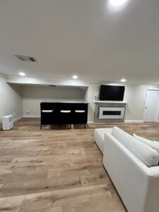 A newly finished basement featuring a modern bar area and an installed electric fireplace by CLE Remodeling Co in Cleveland, OH.