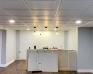 Basement bar renovation in progress, showing new ceiling, lighting, and partially built bar structure by Yellow Ladder Contracting in Mount Pleasant, SC