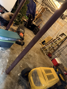 A cluttered basement with lawn equipment needing removal by Marc & Park Junk Removal, LLC in Birmingham, AL.