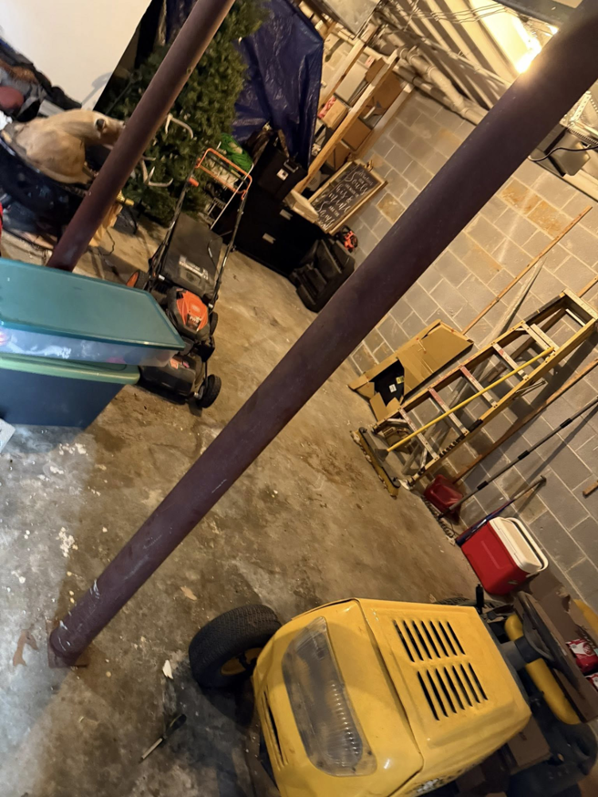 A cluttered basement with lawn equipment needing removal by Marc & Park Junk Removal, LLC in Birmingham, AL.