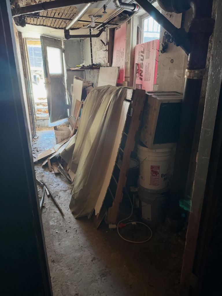 A large pile of basement debris including wood, insulation, and buckets, awaiting removal by Junk Beasts LLC in Marlborough, MA