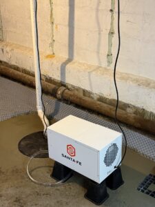 A Santa Fe dehumidifier unit installed in a basement with a waterproofing system by B-Dry System of New England in North Billerica, MA.