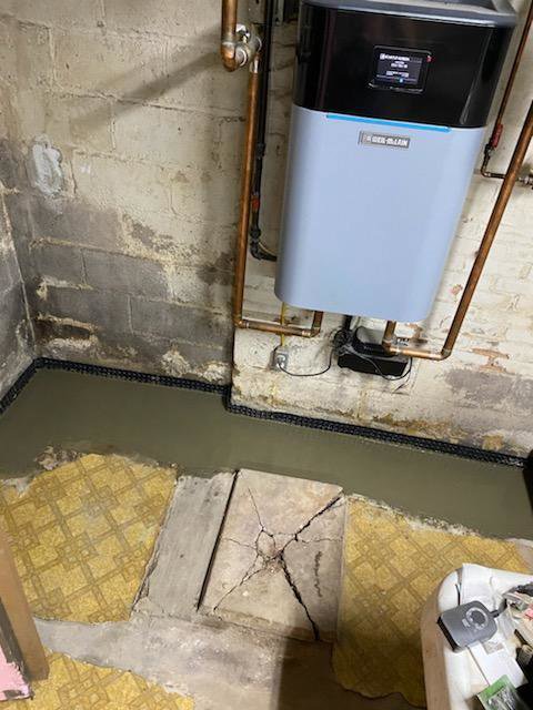 Basement drainage system installed near a water heater by ARK Basement Services - Erie, PA