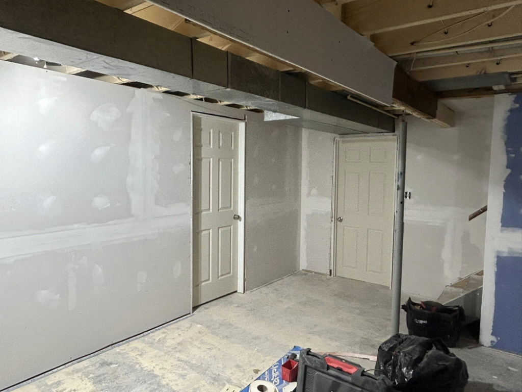 Newly installed drywall and doors in a basement renovation by Pinnacle Roofing & Construction LLC in Elkhart, IN.