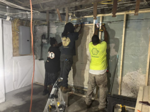 Construction crew installing drywall in a basement renovation project by Ridgely Home Services LLC in Pittsburgh, PA.