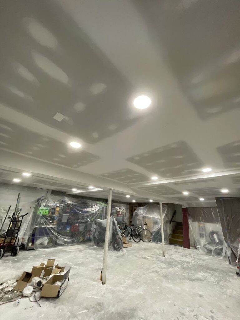 Basement interior with new drywall and recessed lighting installed by Sanchez & Hall Construction in Richmond, VA.