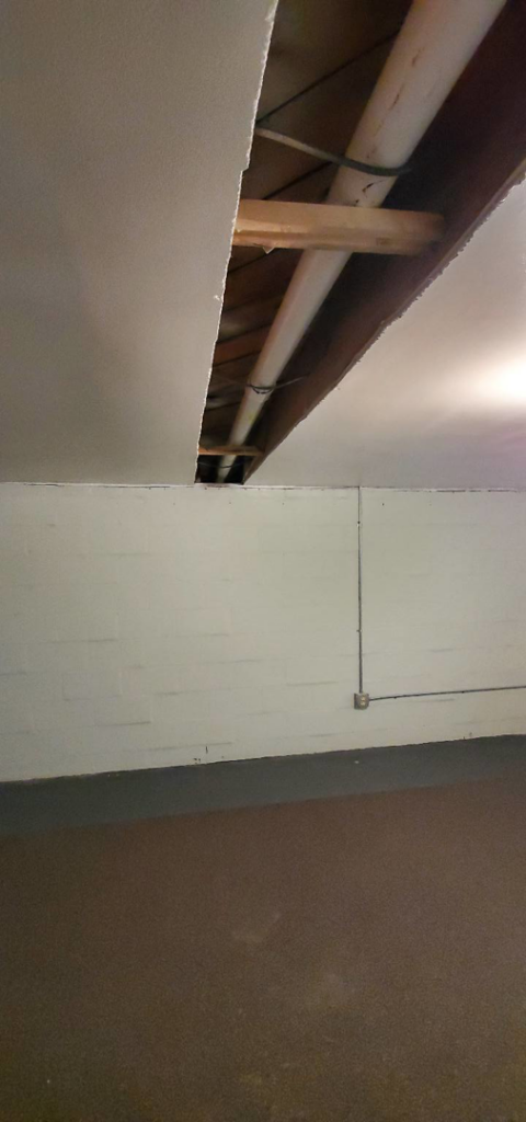 An interior basement with an exposed ceiling showing radon mitigation piping installed by All Ohio Radon Services in Akron, OH.