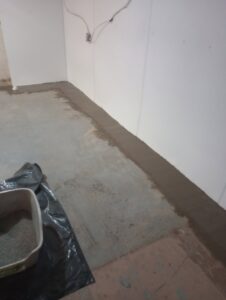 A newly patched concrete floor along a basement wall for drainage by The Basement Doctor in Reynoldsburg, OH.