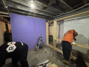 Construction workers framing a new wall in a basement for Ridgely Home Services LLC in Pittsburgh, PA.