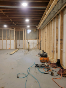 A basement interior showing new wall framing and construction tools by JDS Home Improvement in Gaithersburg, MD.