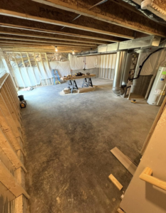An unfinished basement with new framing and construction materials, showing a remodeling project by Jason Roberts Painting and Remodeling in Louisville, KY.